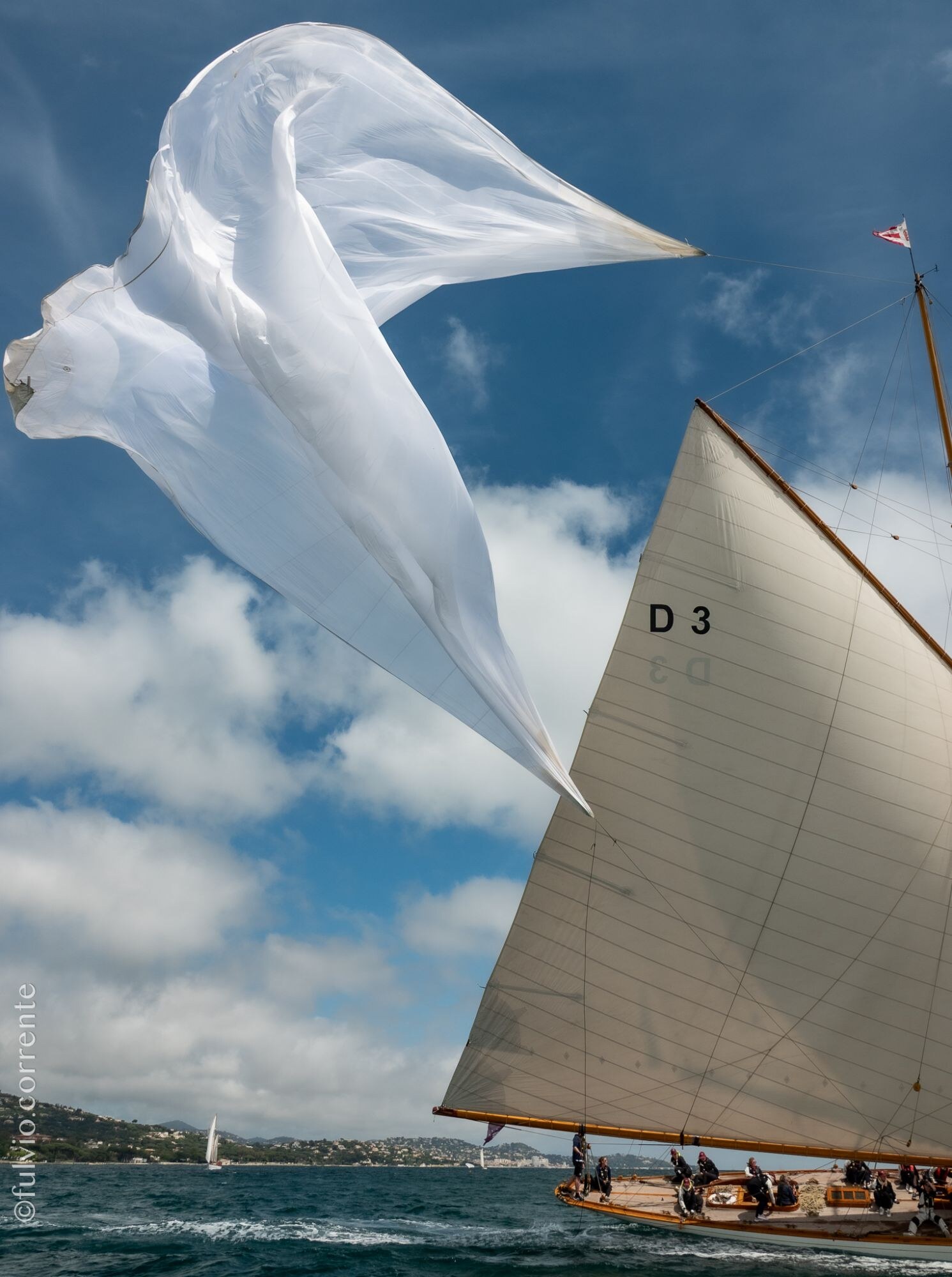 Voile blanche flottant dans le vent sur le ciel, voilier à voile beige marqué D 3.