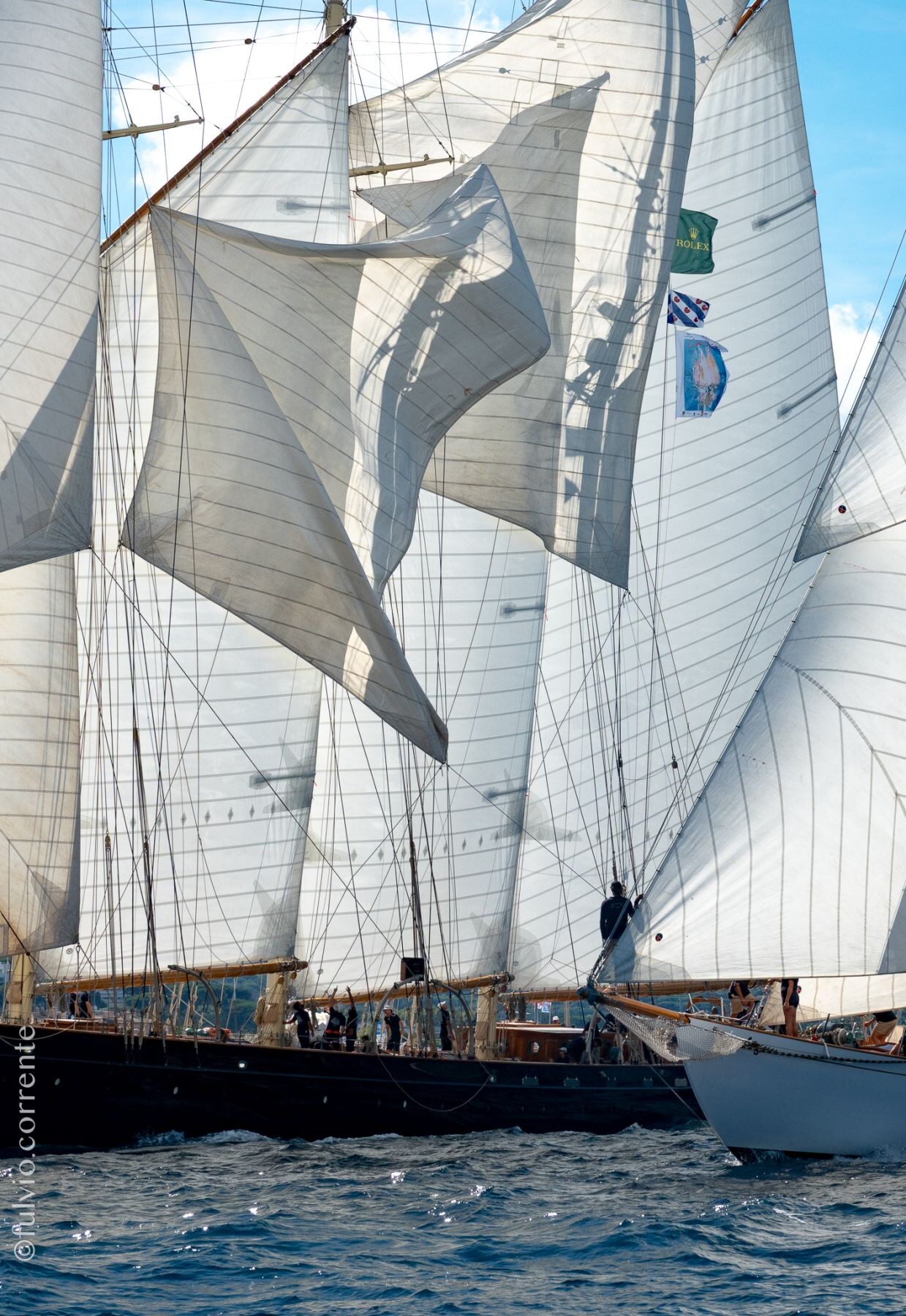 Voiles claquantes de plusieurs grands voiliers serrés les uns contre les autres.