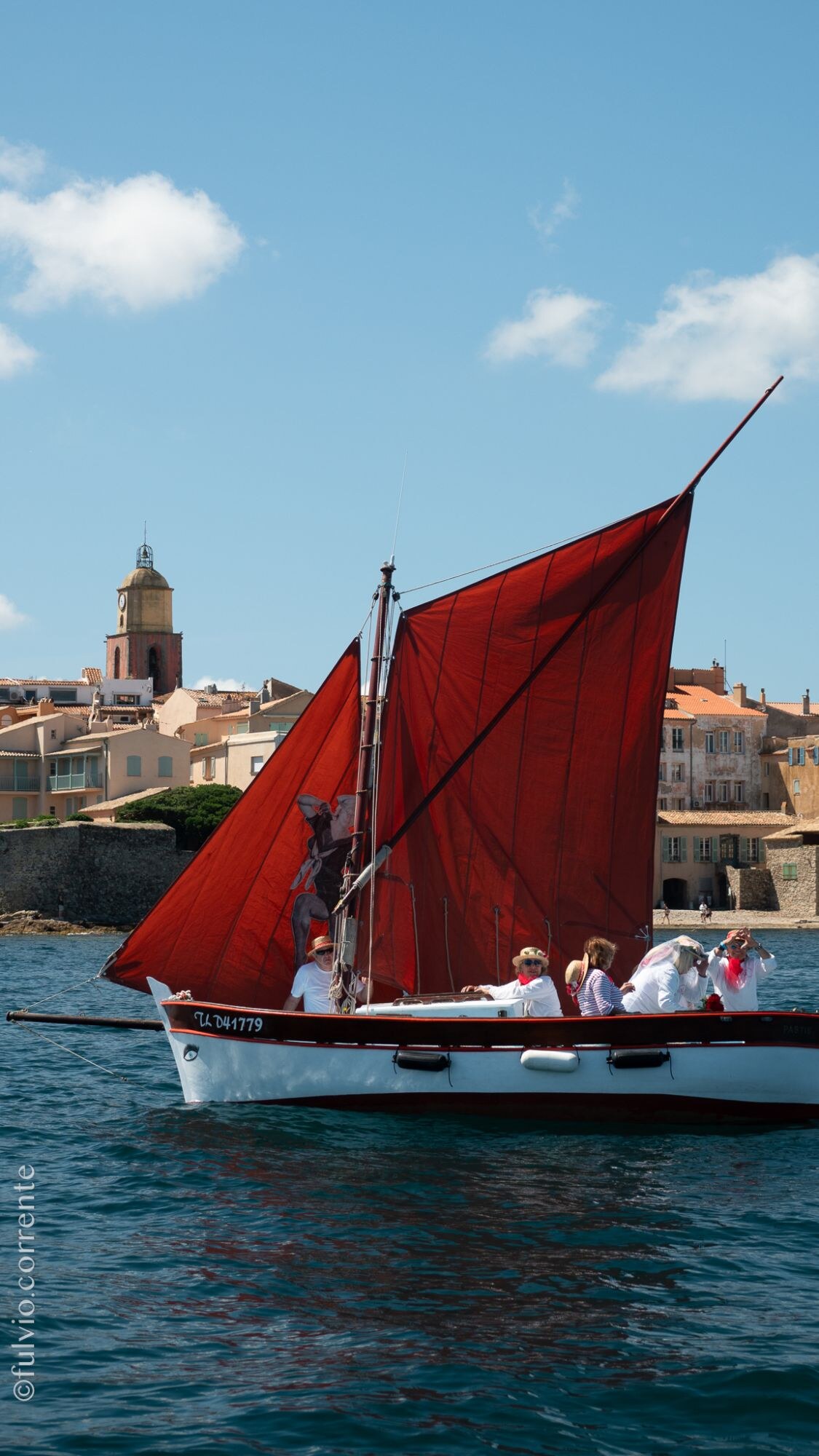 Barque à voiles rouges devant le clocher de Saint-Tropez.